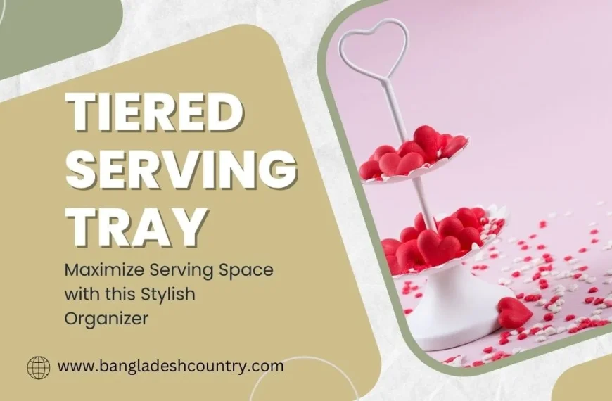 A promotional image featuring a white two-tier serving tray with a heart-shaped handle, filled with red heart-shaped candies, set against a light pink background scattered with red and white sprinkles. On the left, large text reads 'TIERED SERVING TRAY', with smaller text below 'Maximize Serving Space with this Stylish Organizer', and 'www.bangladeshcountry.com'.