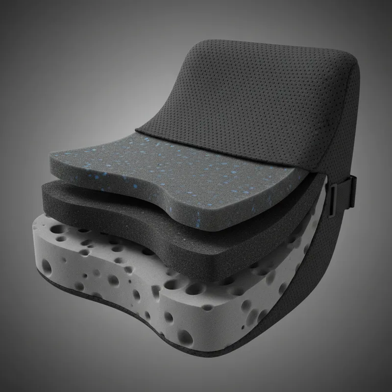 A close-up, cutaway view of a black memory foam lumbar support dark pillow, showing the layered internal structure of the foam and the breathable fabr