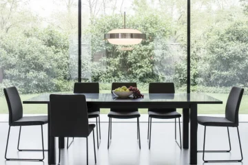 Modern black dining table with 6 matching black chairs in a minimalist style. Contemporary dining set for a kitchen or dining room.