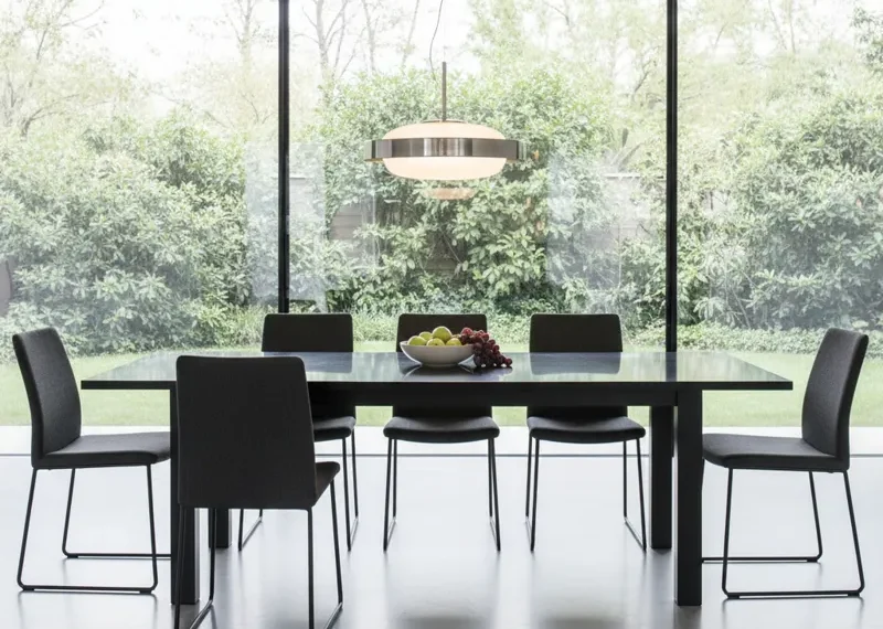 Modern black dining table with 6 matching black chairs in a minimalist style. Contemporary dining set for a kitchen or dining room.