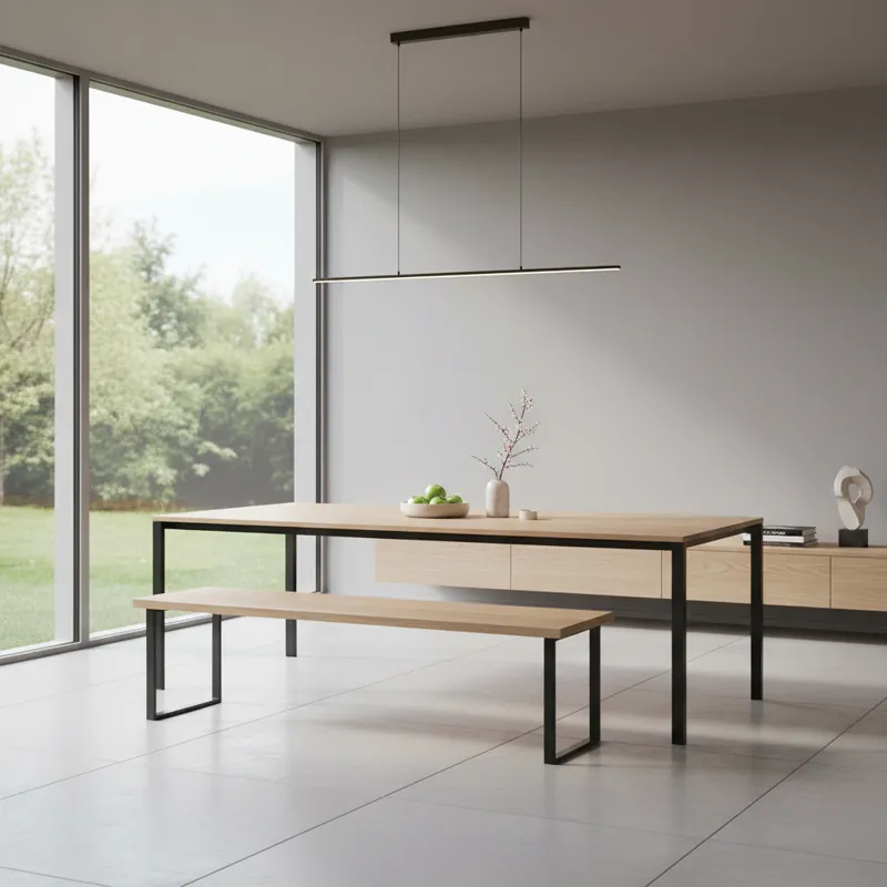 A wide shot of a modern dining room featuring a sleek, backless contemporary dining table bench made of light wood, tucked neatly under a minimalist d