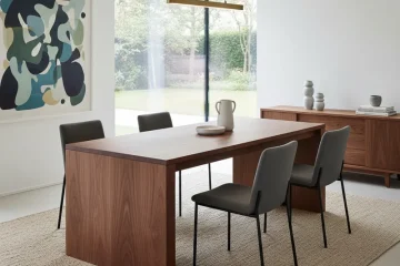 Sleek modern walnut dining table with a minimalist design, smooth wood grain, and clean lines, perfect for contemporary dining spaces.