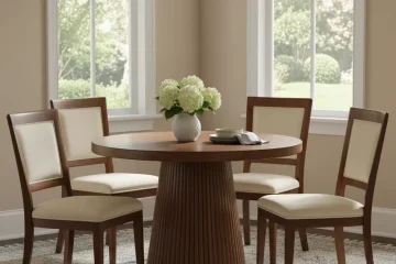 A modern white pedestal dinette set with a round table and four comfortable chairs, ideal for a kitchen or small dining room.
