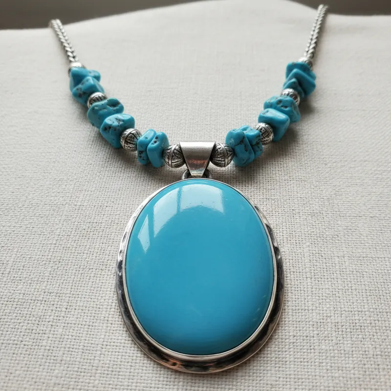 A high-quality image of a genuine Sleeping Beauty turquoise necklace with a prominent pendant, showcasing its vivid, robin's egg blue color and smooth