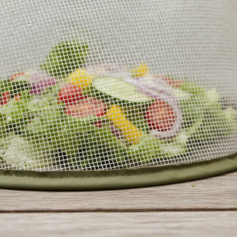 A close-up, macro photography shot of a high-quality food cover mesh weave showing a tight grid pattern, contrasted against a blurred background of a