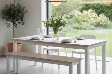 White modern dining table paired with a matching white dining bench, set in a clean, minimalist dining room or kitchen.