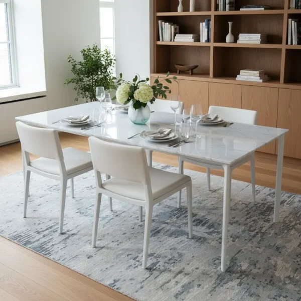 Modern white dining table with four minimalist chairs in a bright, clean dining room setting.