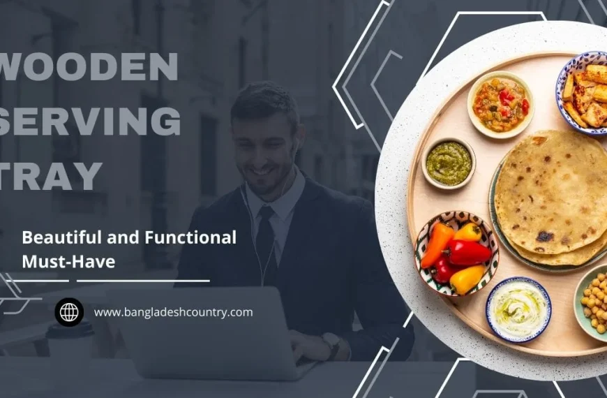 A round wooden serving tray displaying a variety of colorful South Asian dishes, including flatbreads, curries, and dips. The image features a smiling man working on a laptop in the blurred background and prominent text 'WOODEN SERVING TRAY' and 'Beautiful and Functional Must-Have'.